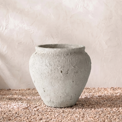Concrete pot on a textured surface with a neutral background