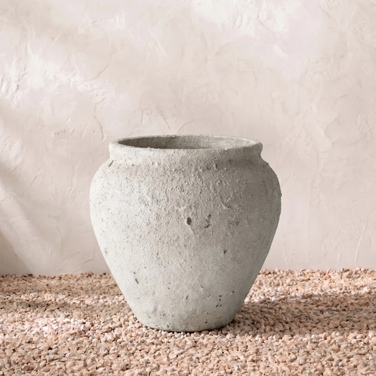 Concrete pot on a textured surface with a neutral background