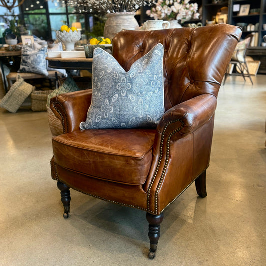 The Kensington armchair features aged top grain cow hide with classic diamond buttoning and brass stud detailing on the inside back. Its timber frame provides solid construction and durability, making it a lasting statement piece for any living space. Front