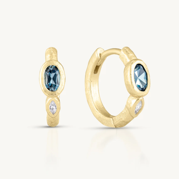 These textured huggies sparkle with a rich oval&nbsp;London Blue Topaz complimented by a marquise Cubic Zirconia accent.
Whether worn solo for a touch of understated elegance or mixed into your favourite stack, they are an invitation to express your creative spirit.