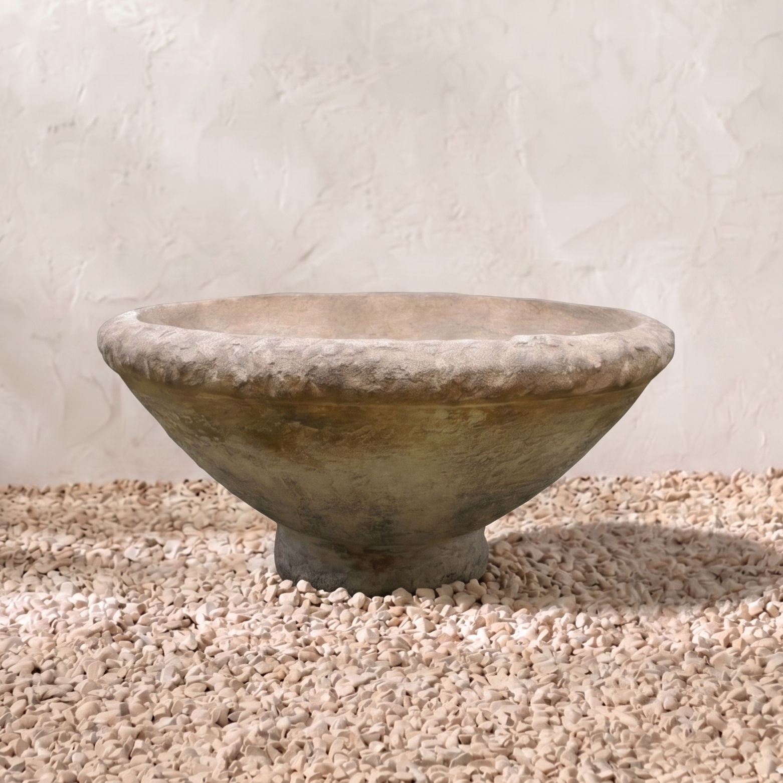 Stone bowl on a gravel surface with a light background