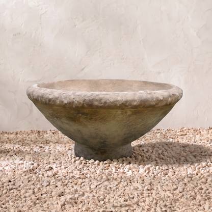 Stone bowl on a gravel surface with a light background