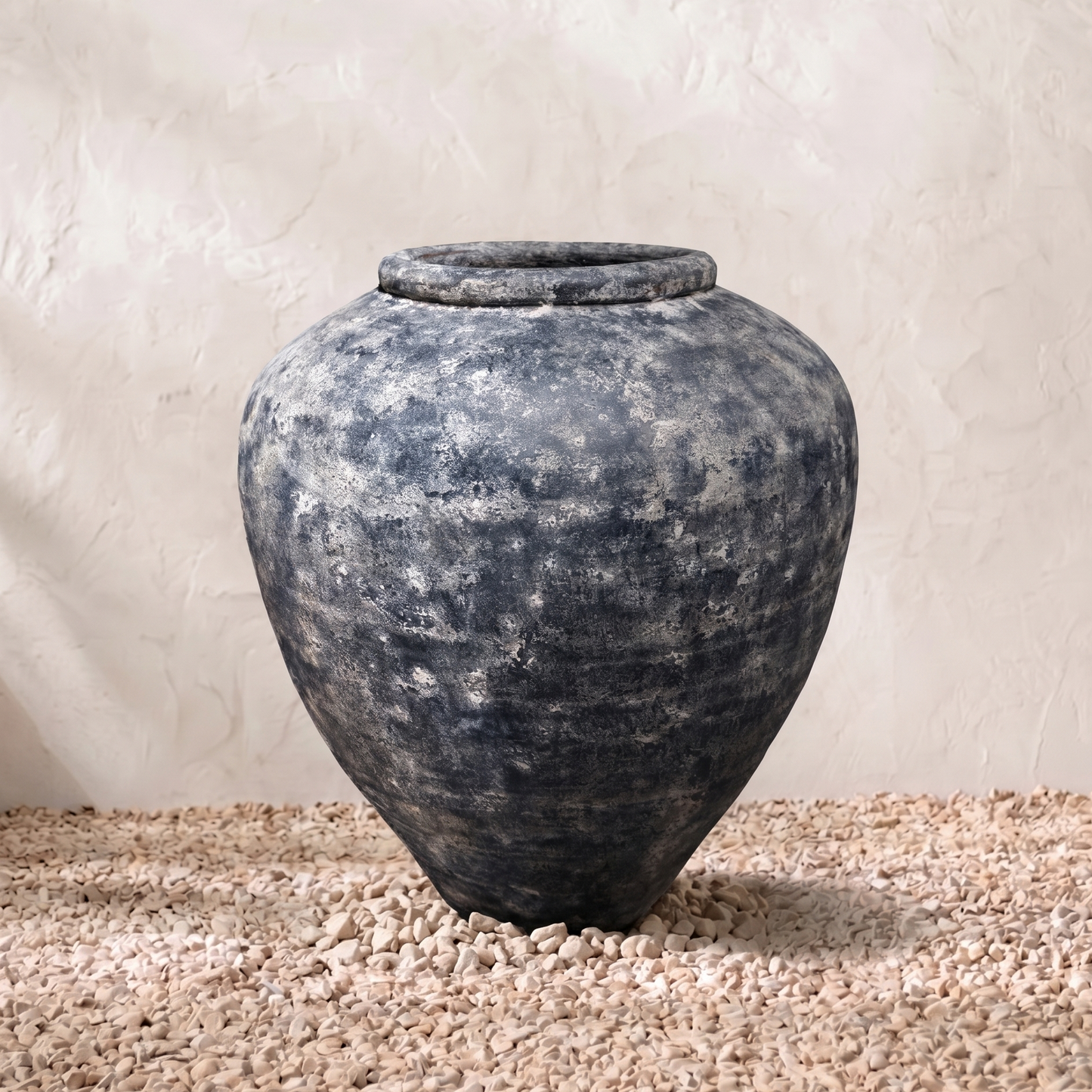 Vintage-style terracotta pot on a textured surface with a neutral background