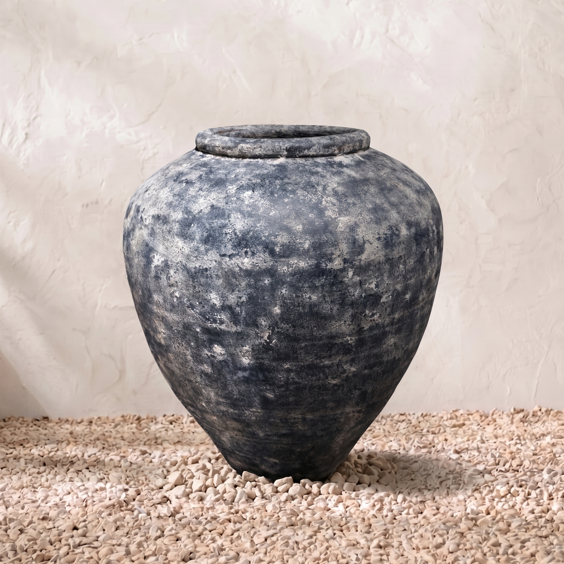 Vintage-style terracotta pot on a textured surface with a neutral background