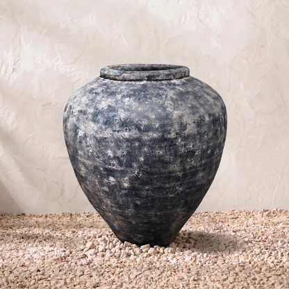 Vintage-style terracotta pot on a textured surface with a neutral background