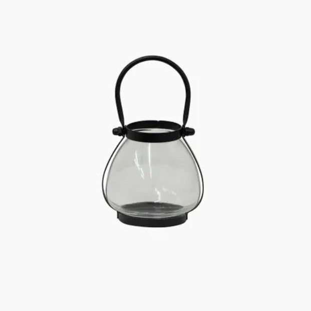 Clear glass lantern with black handle on a white background