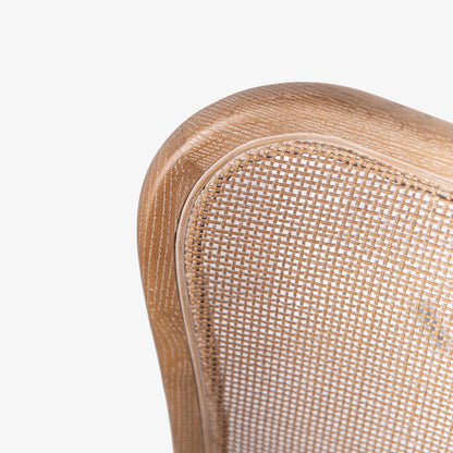 Close-up of a wooden chair with woven backrest on a white background