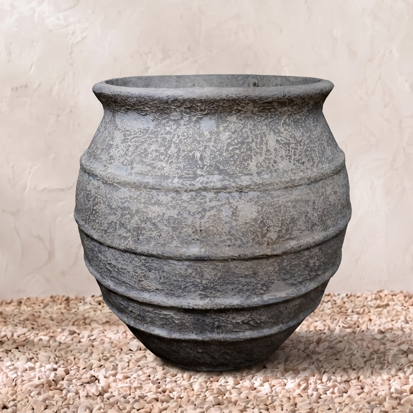 Decorative stone vase on a textured surface with a neutral background