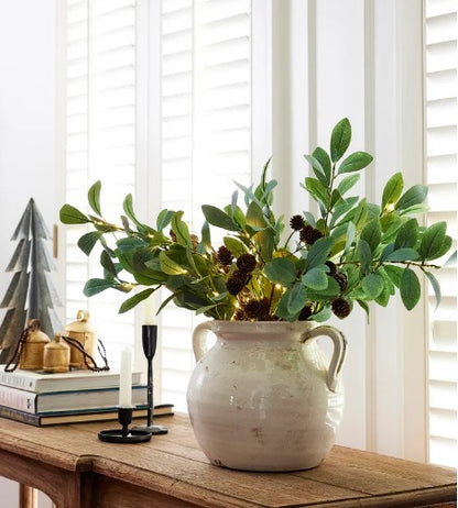 This Faux Olive Light Up Branch is a luxurious addition to any home. 15 LED lights adorn the lovely faux greenery, creating an elegant and timeless look that adds a unique touch to seasonal decor. Perfect for vases or pots, it adds a special ambiance to any space. Styled.