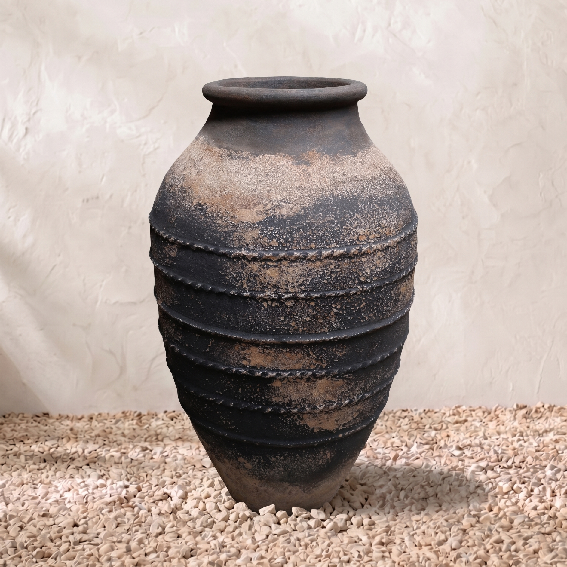 Terracotta pot with layered design on a textured surface