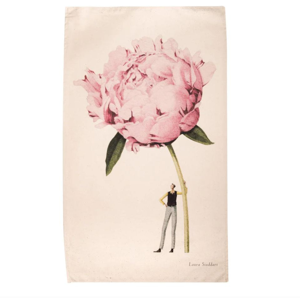 Tea Towel  of a person standing next to a large pink flower on a beige background