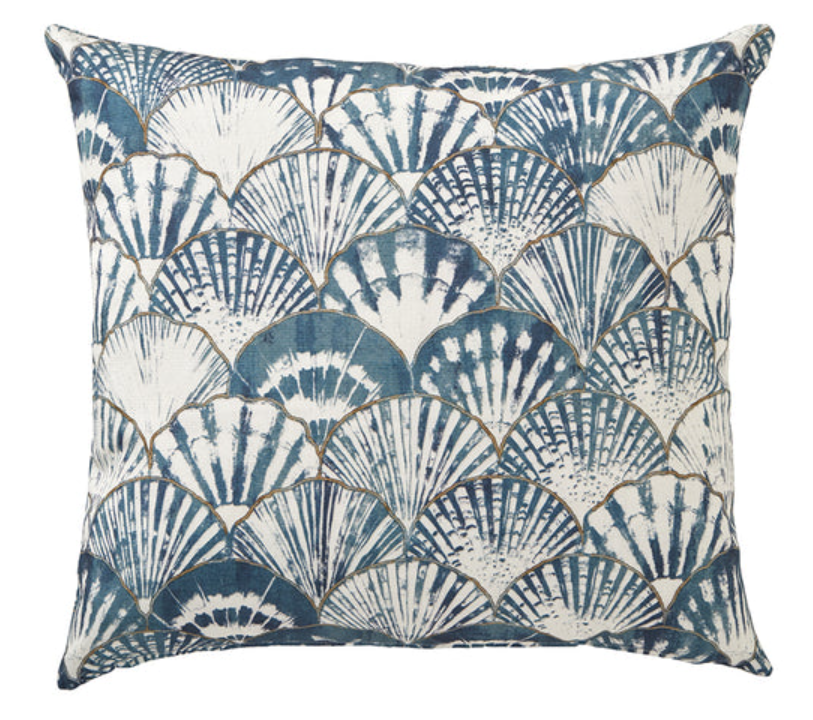 Decorative pillow with blue and white shell pattern on a white background