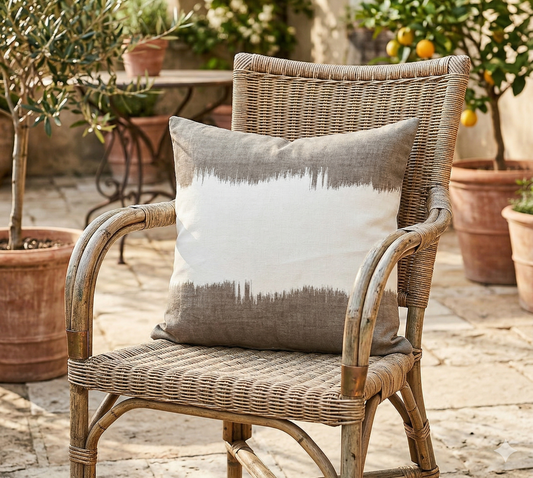 Wicker chair with a decorative pillow on a patio with potted plants