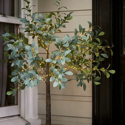 Introduce a realistic touch of nature into your home with the Faux Light Up Olive Tree. This stylish faux greenery is designed with lifelike foliage to deliver a timeless look to your decor. Crafted for durability, this high-quality piece can be used repeatedly. The tree is illuminated with 300 LED chain lights for a beautiful presentation. Display it in a pot or basket for an eye-catching display. Indoor use only. Styled.