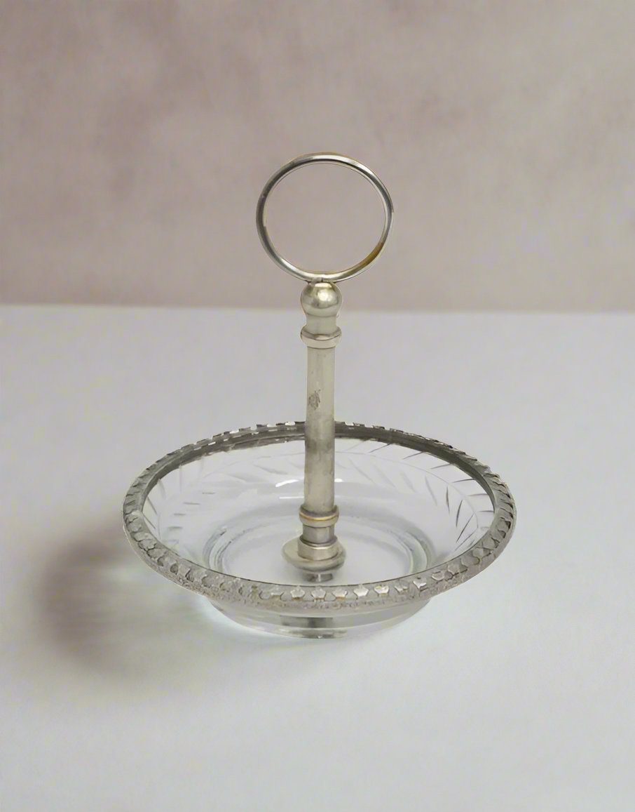 This beautiful Dish carved from brass with a stylish aged silver finish features a graceful cut glass handle. Its ideal size to hold your most meaningful pieces of jewellery and can be placed on your nightstand. 