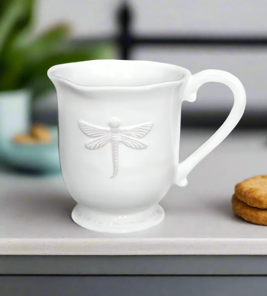 Let your morning routine take flight with our stunning Dragonfly Stoneware White Mug. The rich cream glaze and intricately embossed dragonfly design make it a true statement piece. Plus, its generous size and ergonomic shape ensure a comfortable and enjoyable drinking experience.&nbsp;