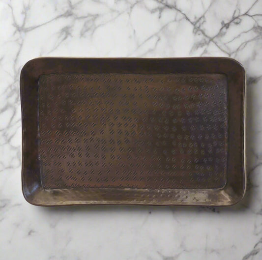 The Luxor Rectangular Tray features a hammered antique brass finish, crafted from aluminium. This versatile tray brings a beautiful warmth with it's brass finish and can be used as a statement decor piece for your home.