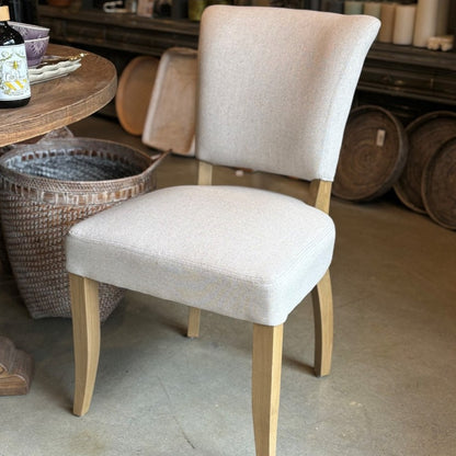 The Chelsea Dining Chair is constructed with a cream linen finish and features stud detailing on the back for a sophisticated, yet comfortable aesthetic.