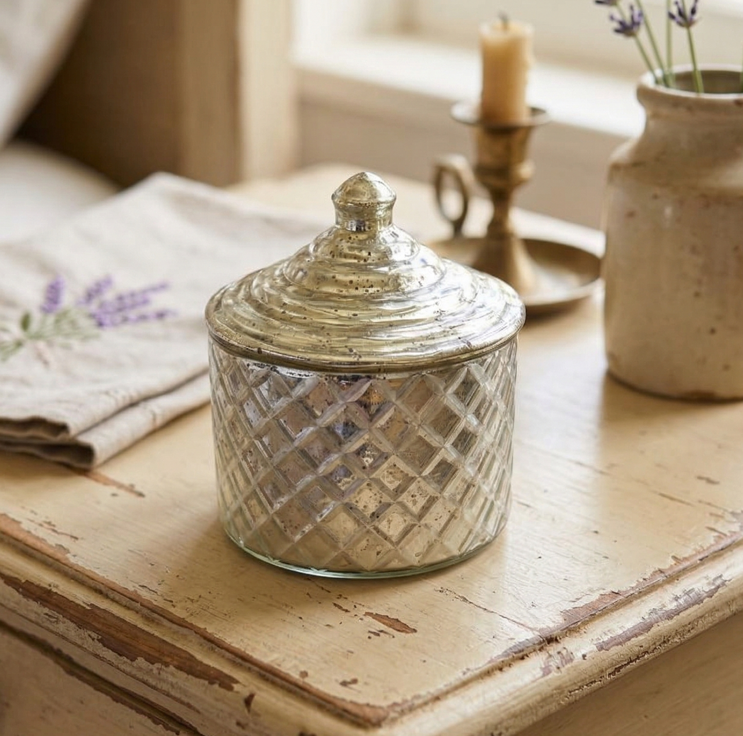 Decorative glass jar with a textured lid on a wooden surface with a soft focus background