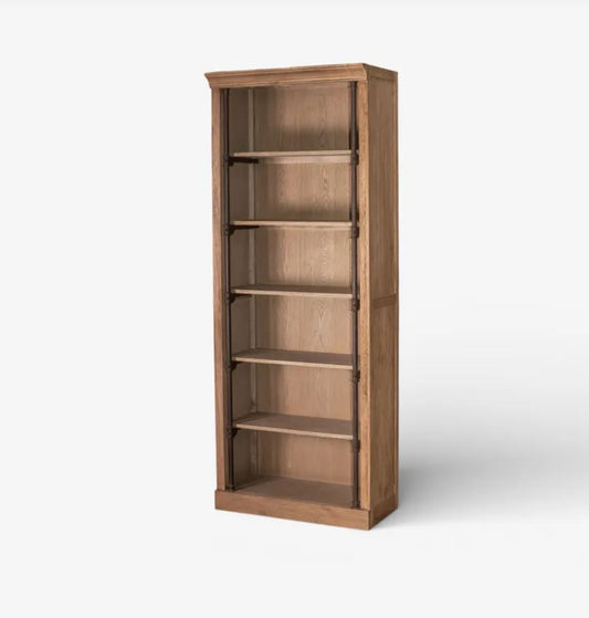 A tall, narrow wooden bookcase with five open shelves, shown at a slight angle on a light gray background.