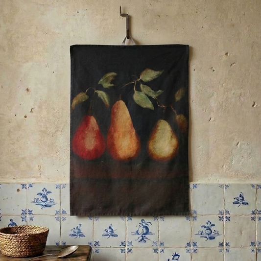 Teatowel with pears hanging on a textured wall with tiled baseboard