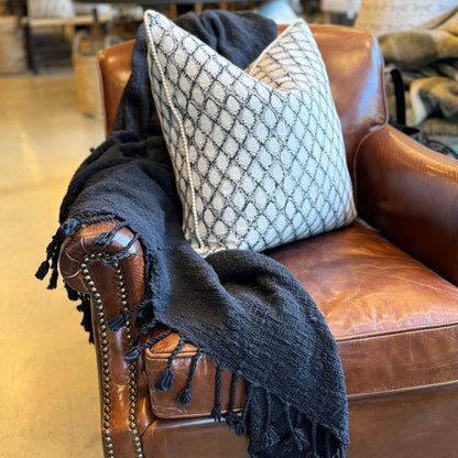 Transform your living spaces into cozy and inviting havens with our handwoven, raw cotton Lucca Black Tassel Throw. The tassel edges and rustic texture add a touch of warmth and comfort to any room. Styled.