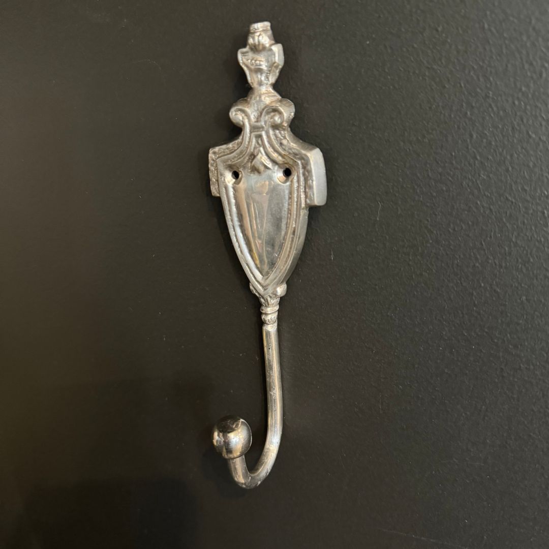 The Royale Silver Hook offers a sophisticated addition to any space, boasting a burnished metal finish adorned with refined detailing. Classic style and function in one item, the Royale Silver Hook is a timeless addition to any decor. Styled.