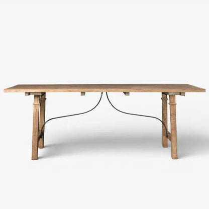 A light natural wood dining table with a rectangular top and four tapered legs, supported by a curved black metal base bar, shown against a plain white background.