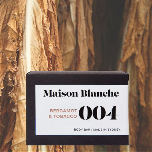 Maison Blanche Bergamot & Tobacco body bar with tobacco leaves in the background