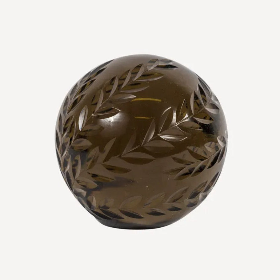 Decorative brown sphere with leaf patterns on a white background