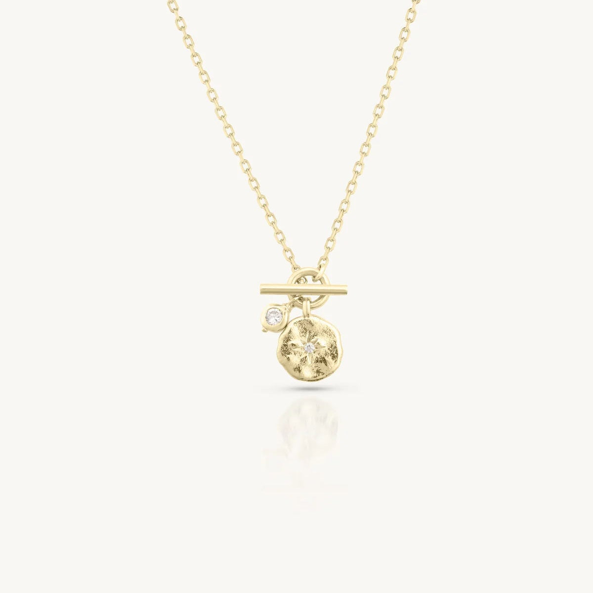 Gold necklace with a small pendant on a white background
