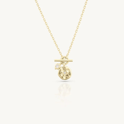 Gold necklace with a small pendant on a white background