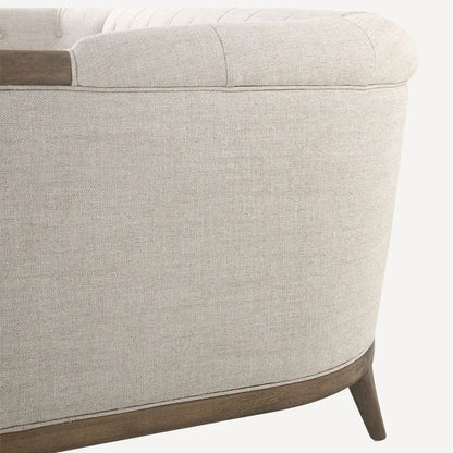 Close-up of a beige upholstered chair with wooden armrests on a white background