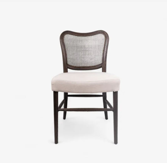 A dining chair with a dark brown wooden frame, a woven cane backrest, and a light beige upholstered seat cushion, shown against a plain white background.