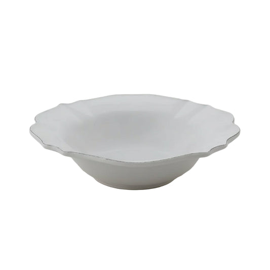 White ceramic bowl with scalloped edge on a light gray background