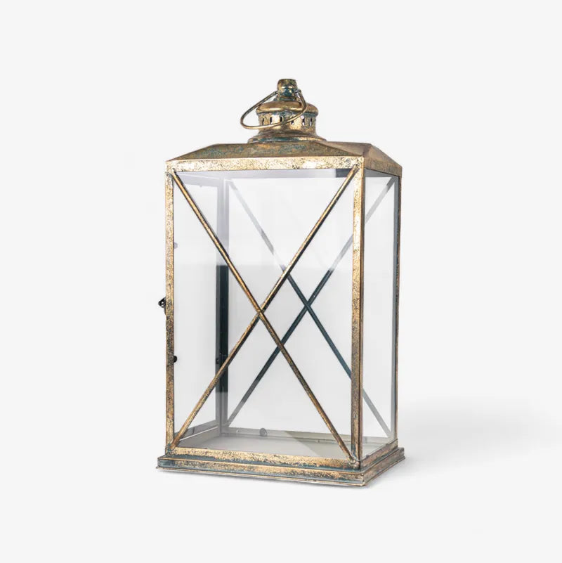 The Calypso Lanterns feature a graceful shape and an aged gold finish that add a cosy, sophisticated touch to any space. It's curved, open structure beautifully diffuses soft ambient light while enhancing your décor with elegance and height. Perfect for layering light indoors or outdoors, these lanterns look stunning on console tables, verandahs, or dining areas, creating a warm and inviting atmosphere.