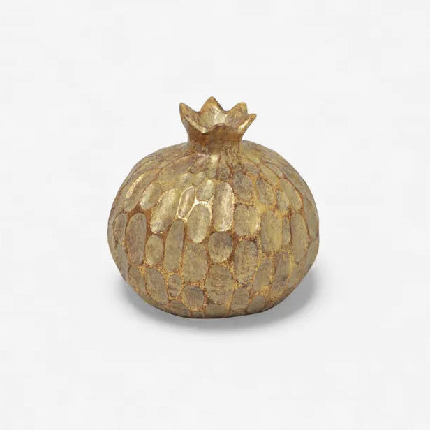 Gold pomegranate decorative item on a white background