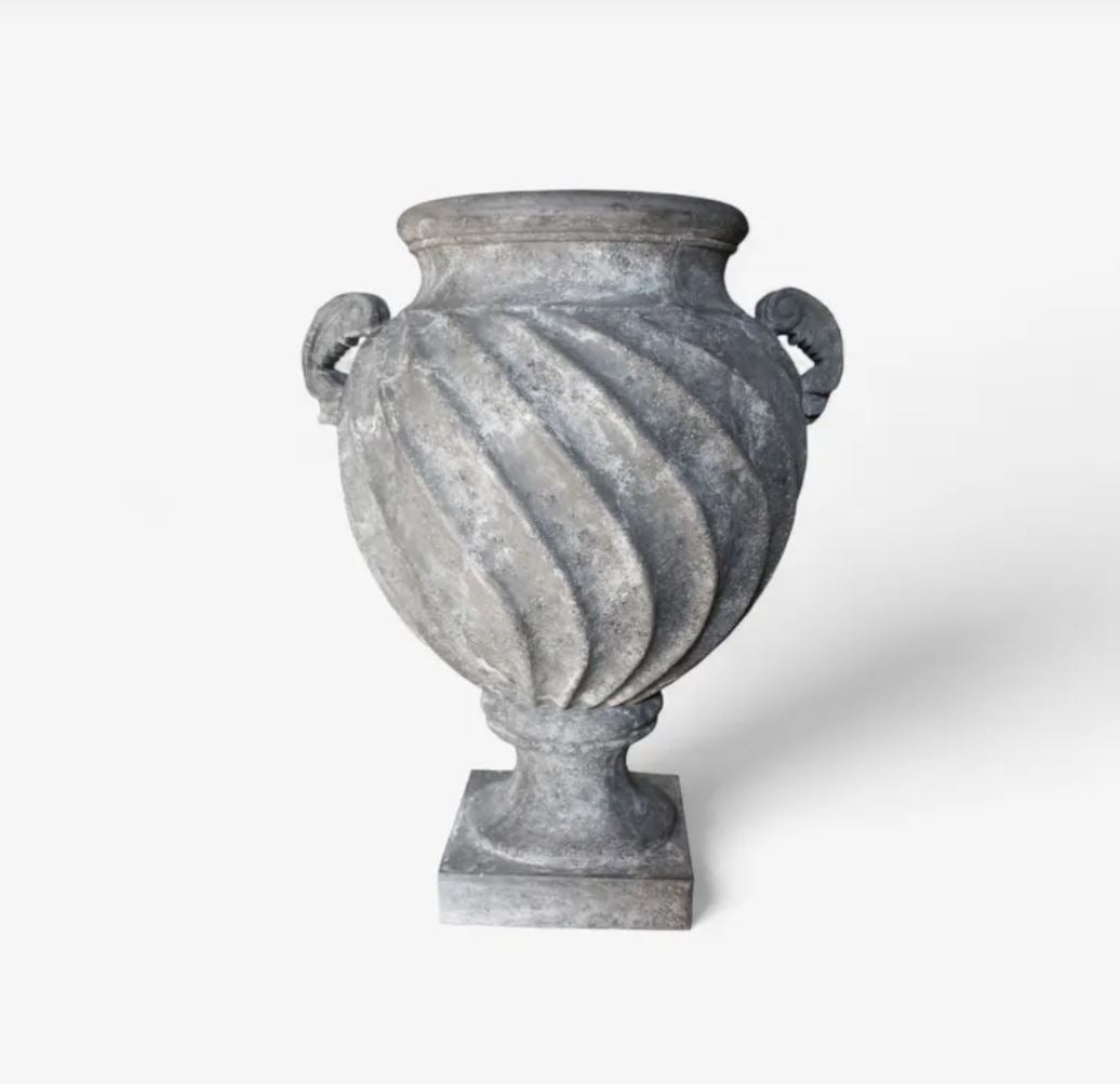 A gray stone-style urn with a fluted spiral pattern, two side handles, and a square pedestal base, shown on a clean white background.