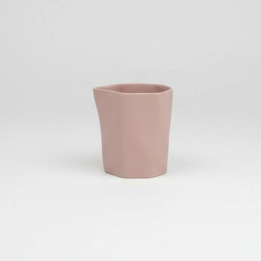Pink ceramic cup on a light gray background