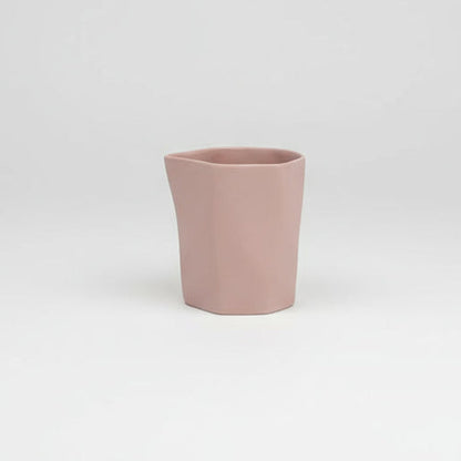 Pink ceramic cup on a light gray background