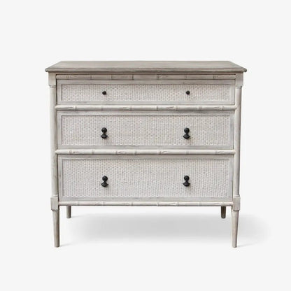 Three-drawer dresser with rattan design and black knobs on a white background