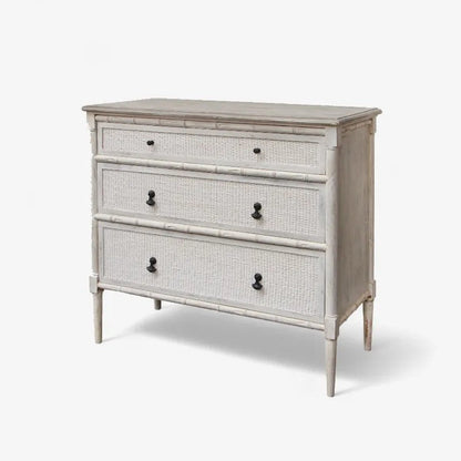 Wooden dresser with white distressed finish and black handles on a white background