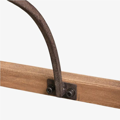 Close-up detail of a rustic metal arch support bracket attached to a wooden rail, shown against a plain light gray background.