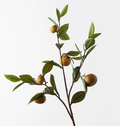 Artificial orange branch with green leaves and small yellow orange on a white background