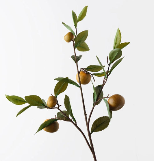 Artificial orange branch with green leaves and small yellow orange on a white background
