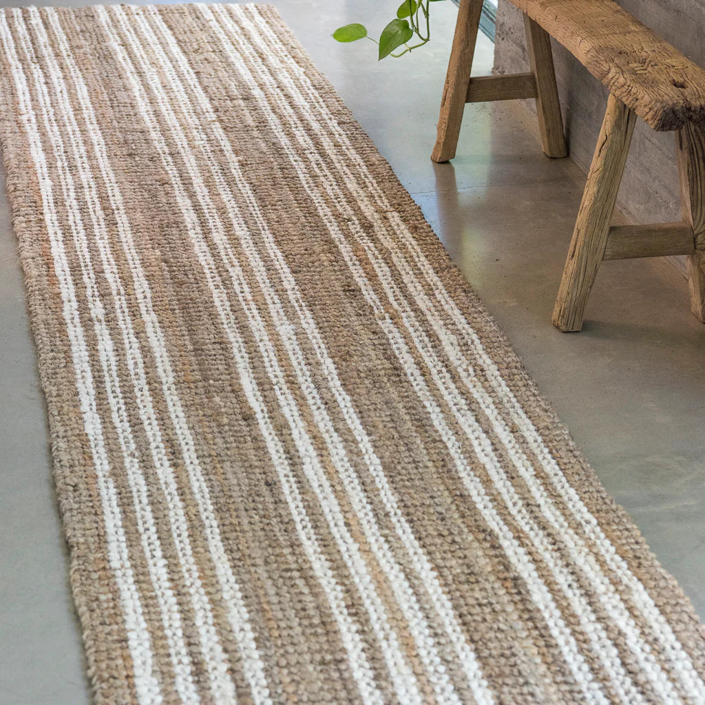 The Osborne Stripe Jute Runner features a white washed stripe on natural jute, adding personality and interest to any home. The stripe runs horizontally on the rug and vertically on the runners, providing a unique touch to hallways and entryways.