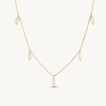 Gold necklace with small pearls on a white background