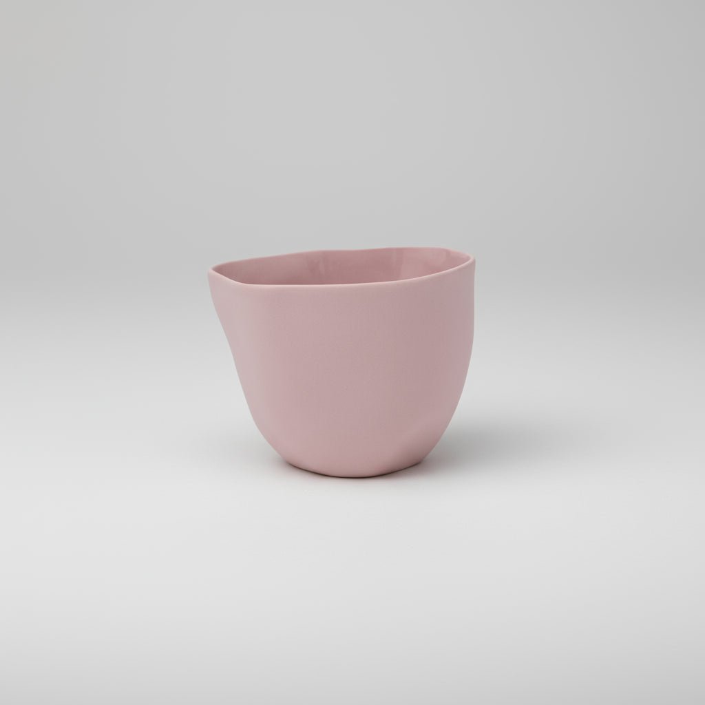 Pink ceramic cup on a white background