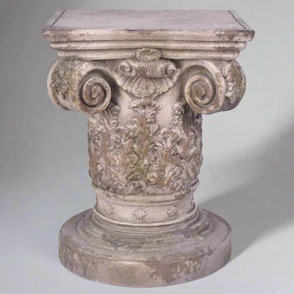 Decorative stone pedestal with intricate carvings on a white background