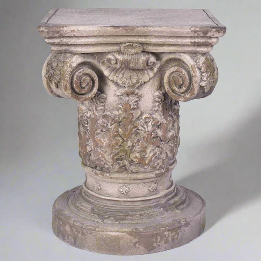 Decorative stone pedestal with intricate carvings on a white background